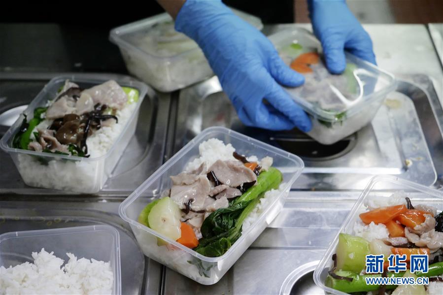 在香港銀杏館餐廳油麻地店,義工在把飯菜裝盒(5月7日攝)。 新華社記者 王申 攝