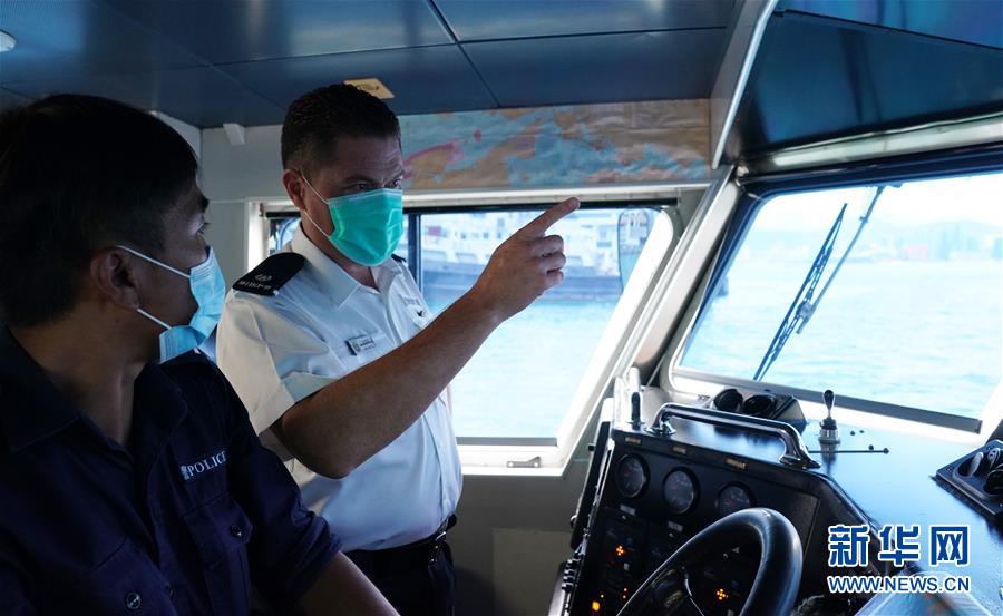 汪伟诺(右)用广东话与同事交流工作(8月6日摄)。 新华社记者 李钢 摄