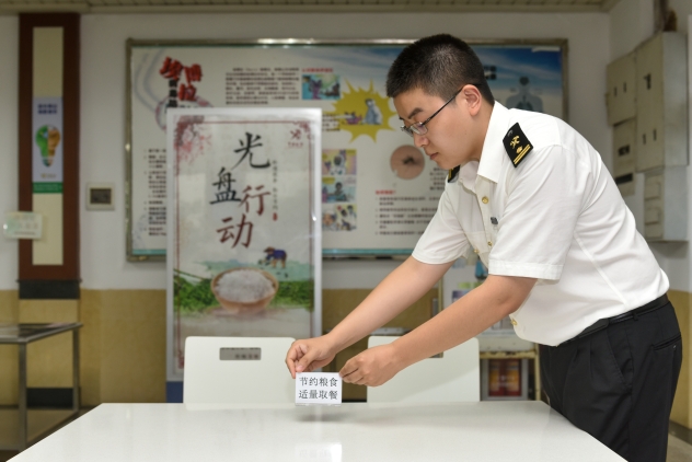 图说:广州海关在食堂餐桌上摆放"节约粮食"提示牌,加强崇尚勤俭宣传