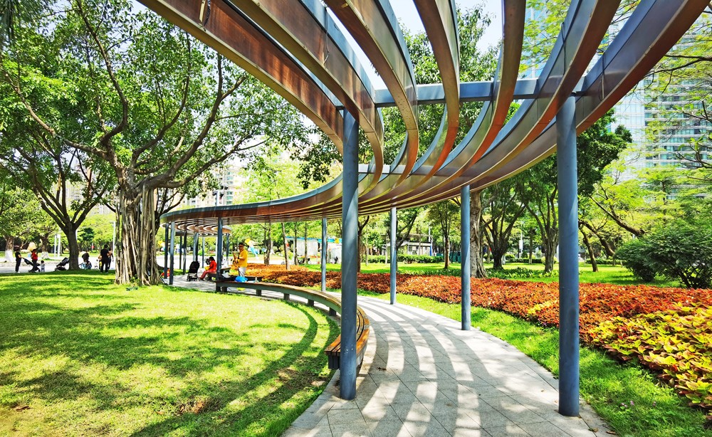 临江大道带状公园弯弯的凉亭下,人们在休闲娱乐.(摄影:何小茹)