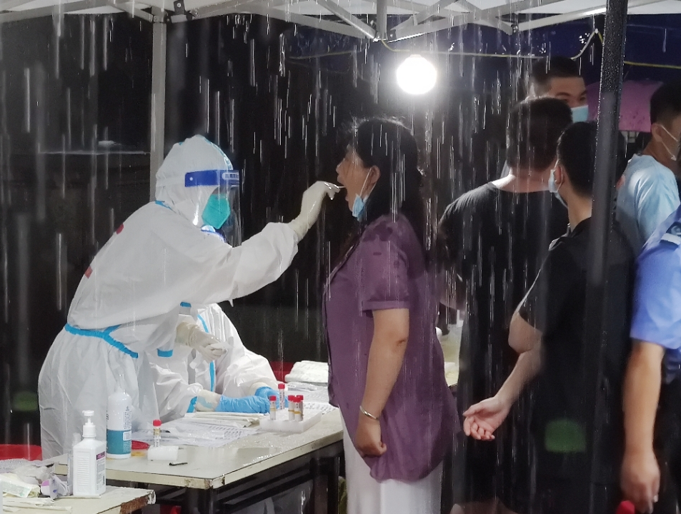在员村街逢源社区医护人员正在冒雨为群众做好核酸检测服务