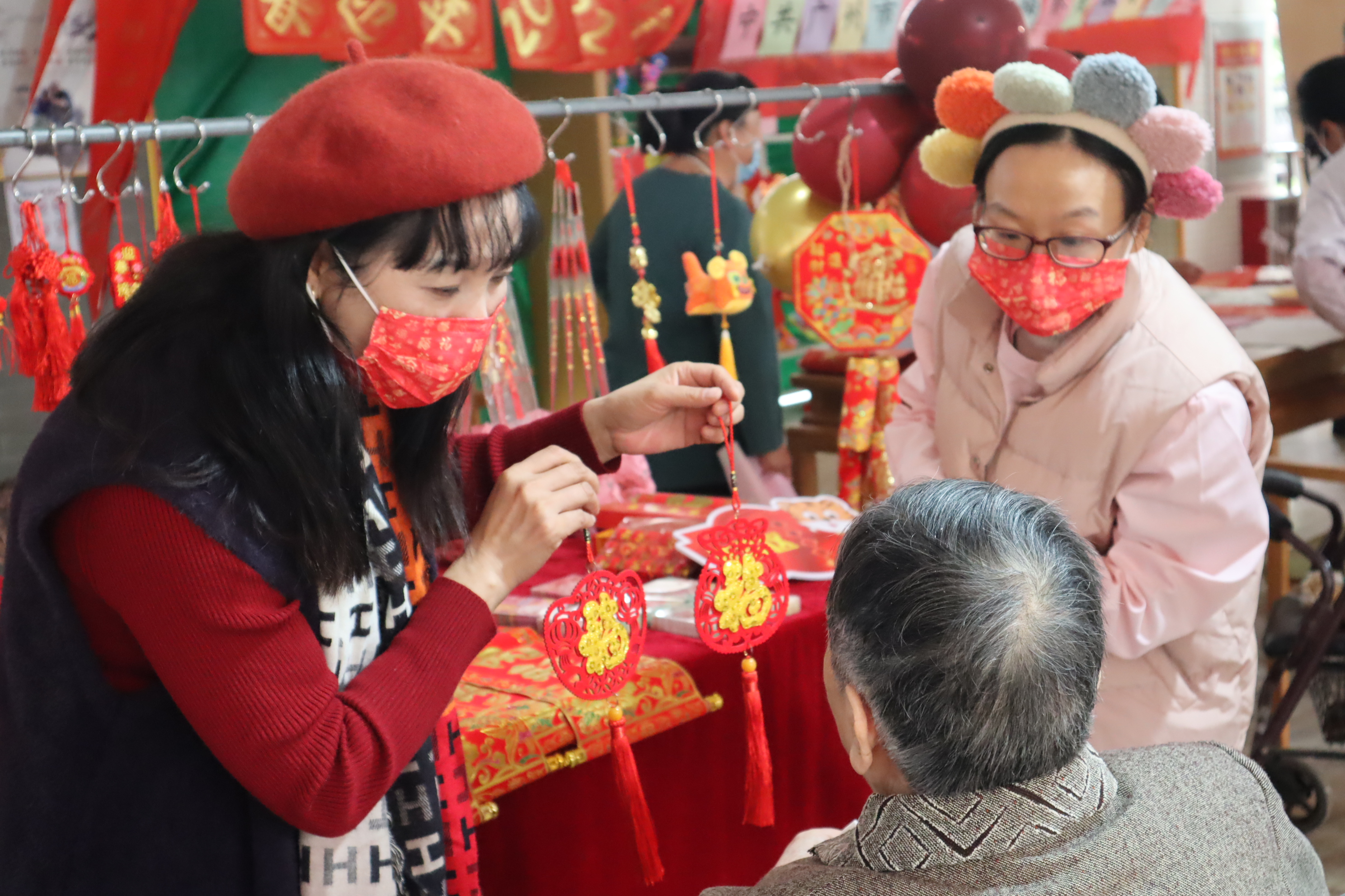 02 年货区,工作人员向长者介绍装饰物品并送祝福