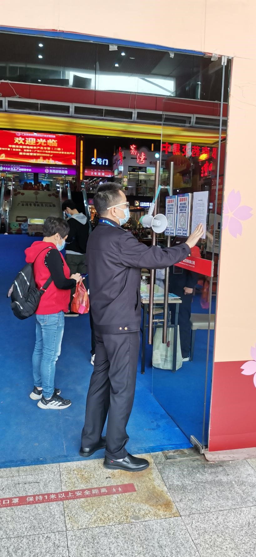 (图:荔湾区市场监管局执法人员在市场入口处粘贴《市场诚信经营倡议书》)