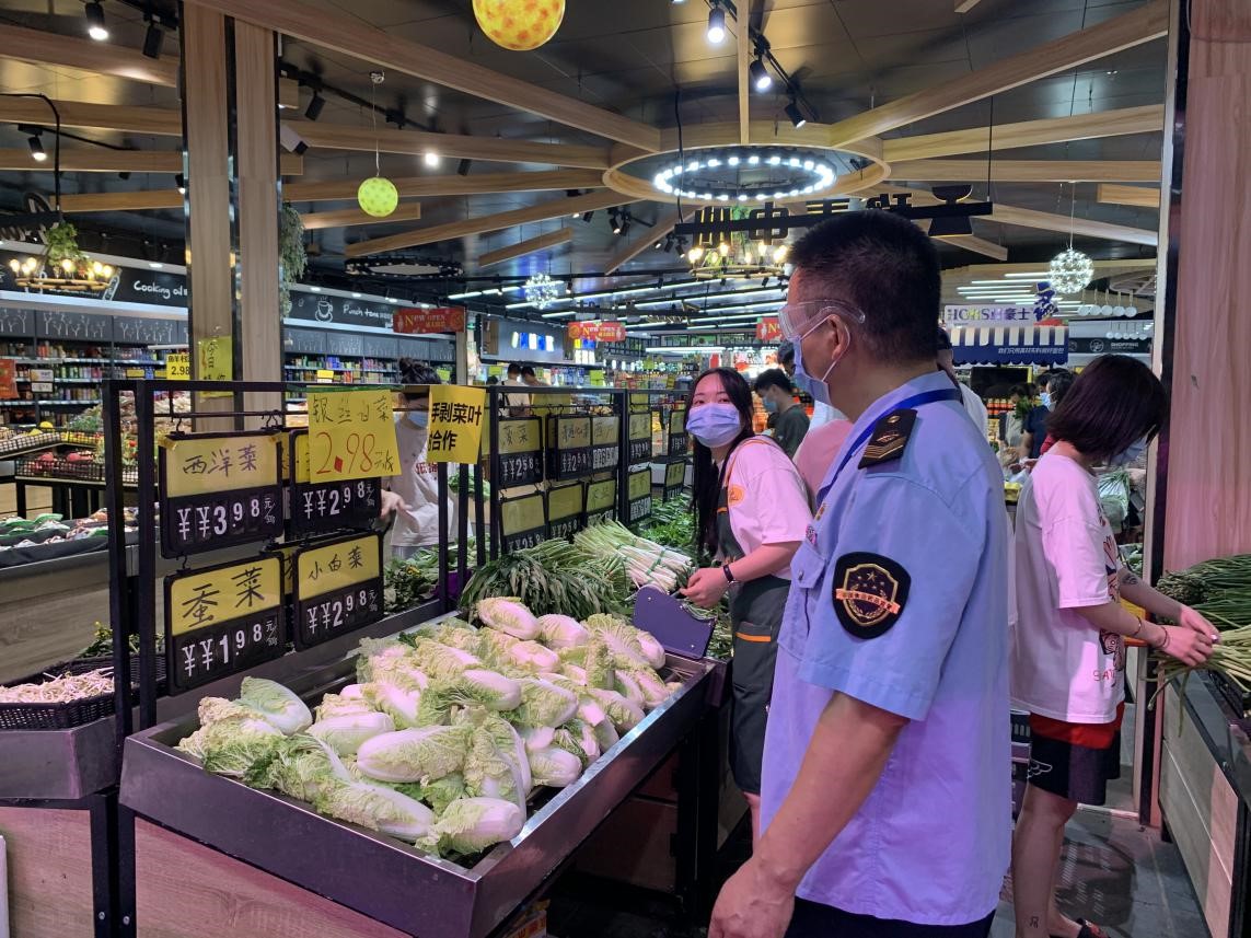 (图:荔湾区市场监管局执法人员监测市场肉菜价格水平)