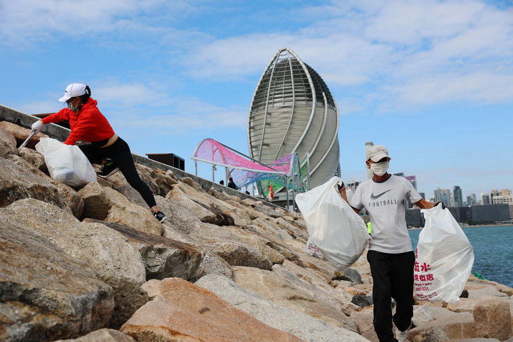 2021年12月7日,義工在香港海邊撿垃圾。新華社記者吳曉初 攝