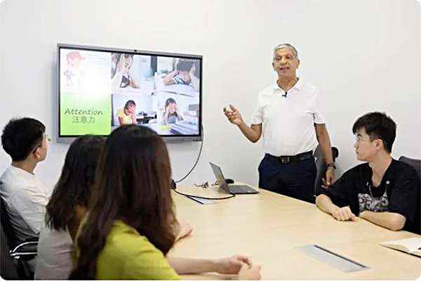 何瑞明(站立者)向团队人员作幻灯片汇报。