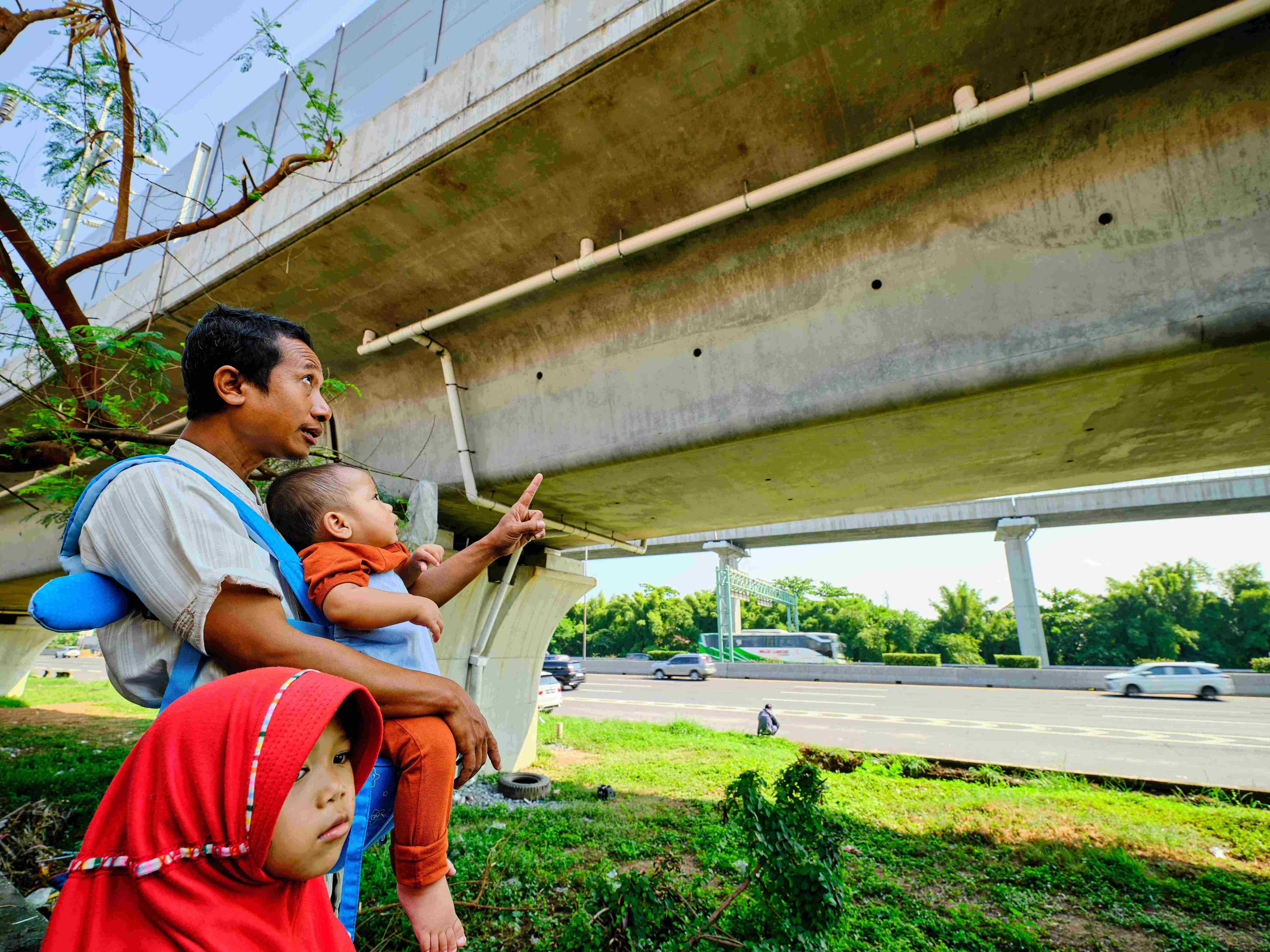 一位抱着孩子的雅加达市民在观看雅万高铁试验列车3